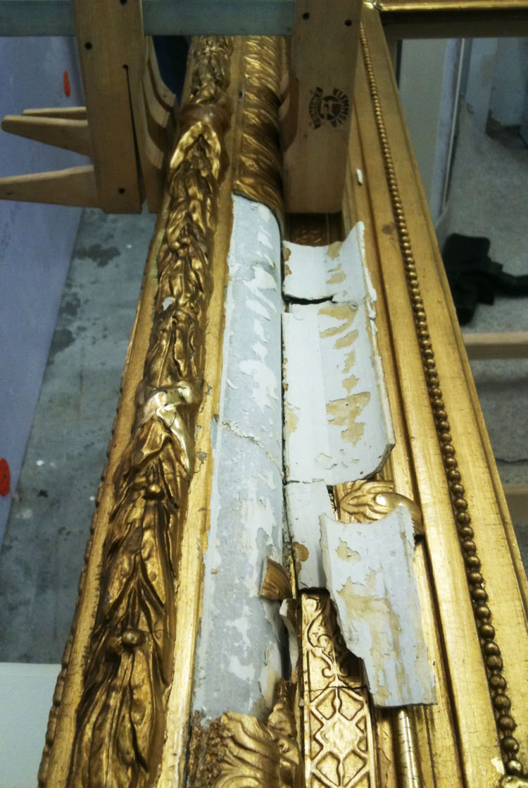 Goldener Bilderrahmen mit beschädigtem und abblätterndem Bereich, teilweise mit weißem Material bedeckt.